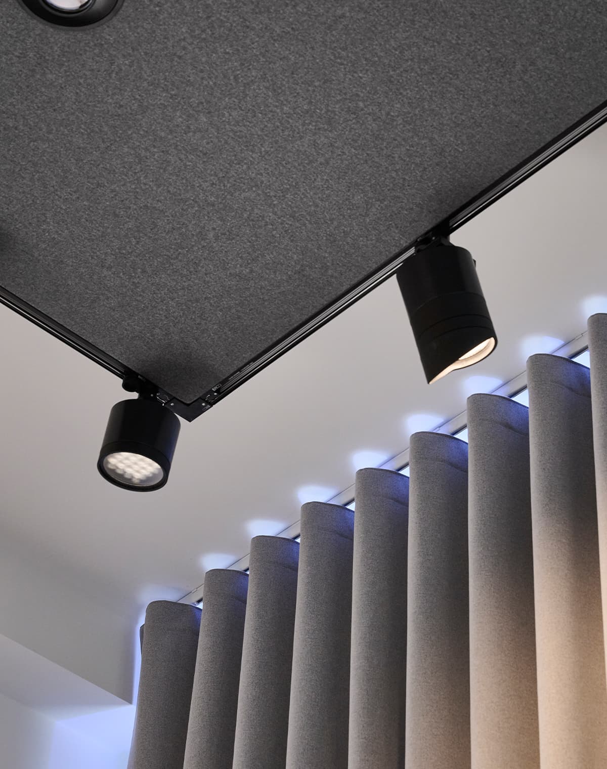 Eine Aufnahme von Akustikpaneelen mit integriertem Licht sowie einem grauen Akustikvorhang.