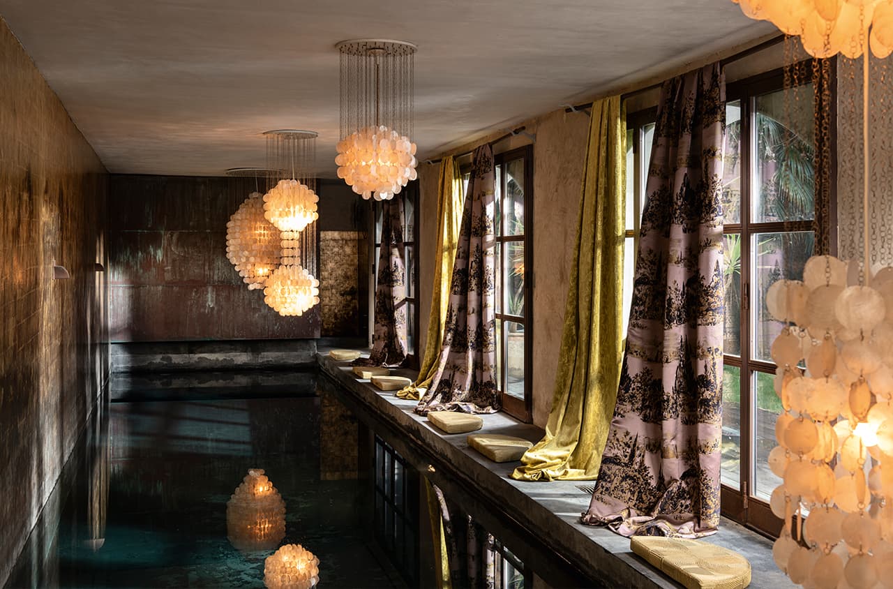 Indoor-Pool und gelbe und lilane Vorhänge an den Fenstern.