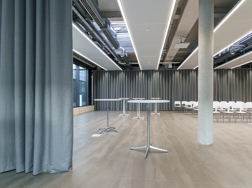 Eine Aufnahme von einem großen Konferenzsaal mit Akustikvorhängen.