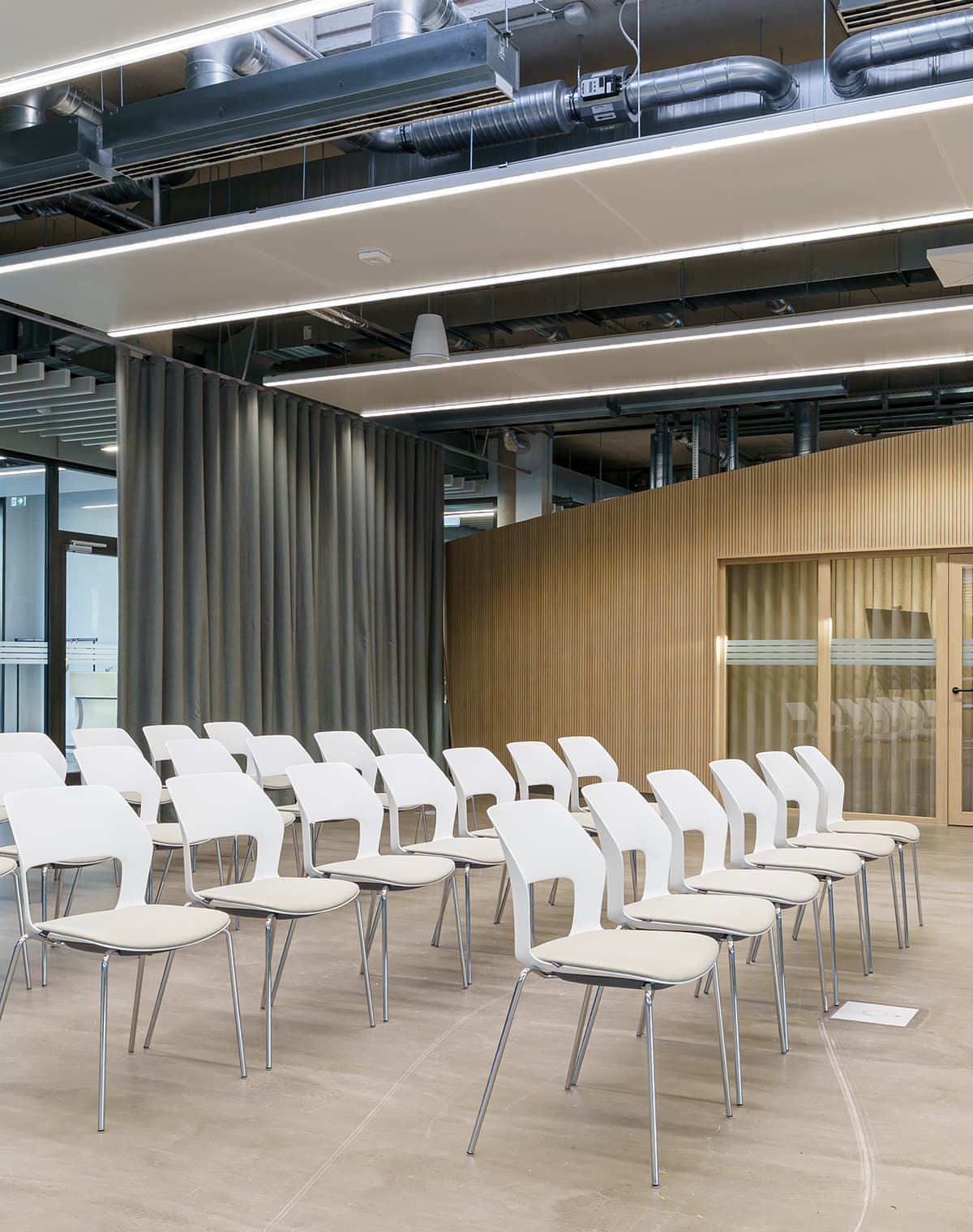 Eine Aufnahme von mehreren Stühlen in einem Konferenzsaal.