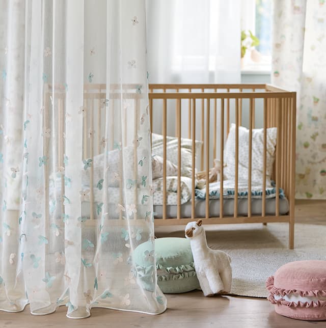 Transparent Gardine mit Schmetterlingen im Kinderzimmer.