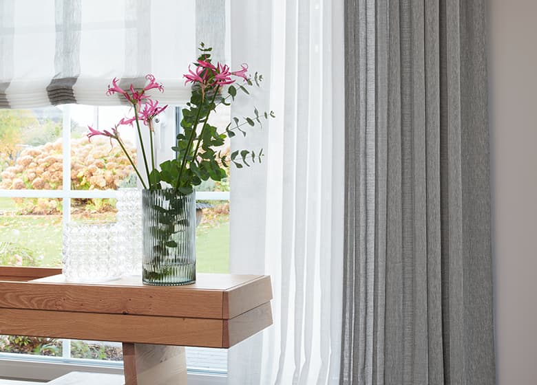 Sitzbank mit Blumen vor einem Dekostoff