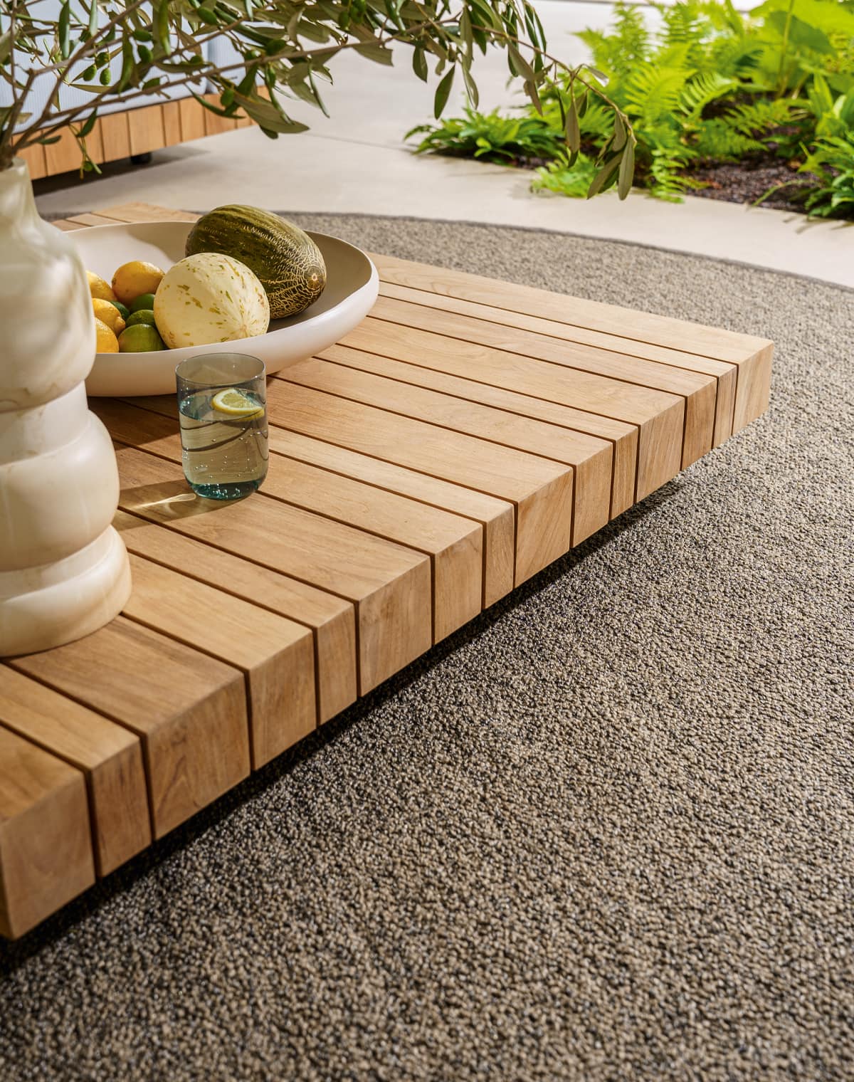 Detailbild von einem Holztisch und Outdoorteppich