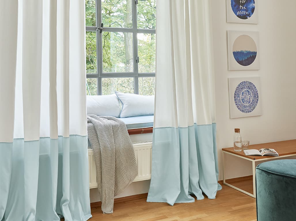 Weiß-blaue Gardine am Fenster