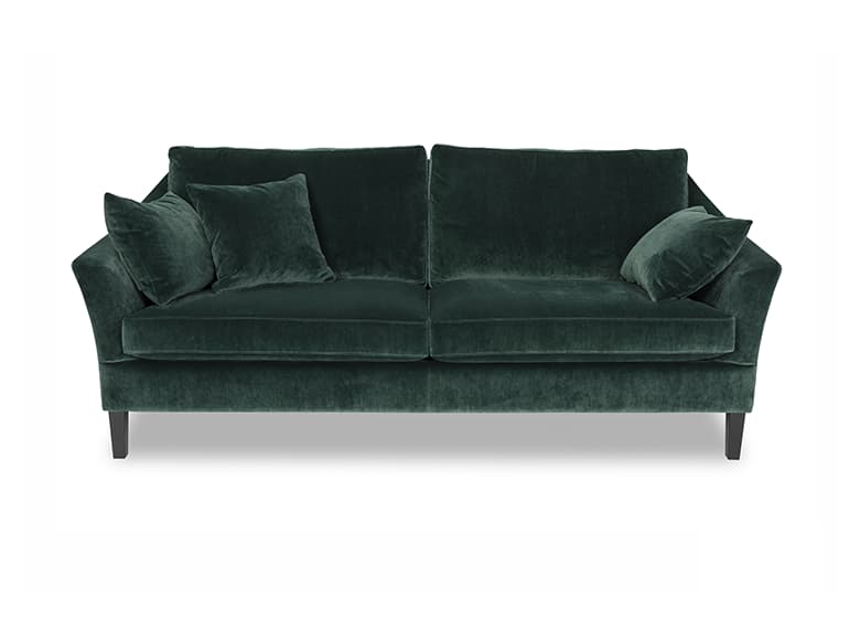 Freisteller eines dunkelgrünen Sofas aus Samt, auf ihm liegen drei gleichfarbige Deko-Kissen.