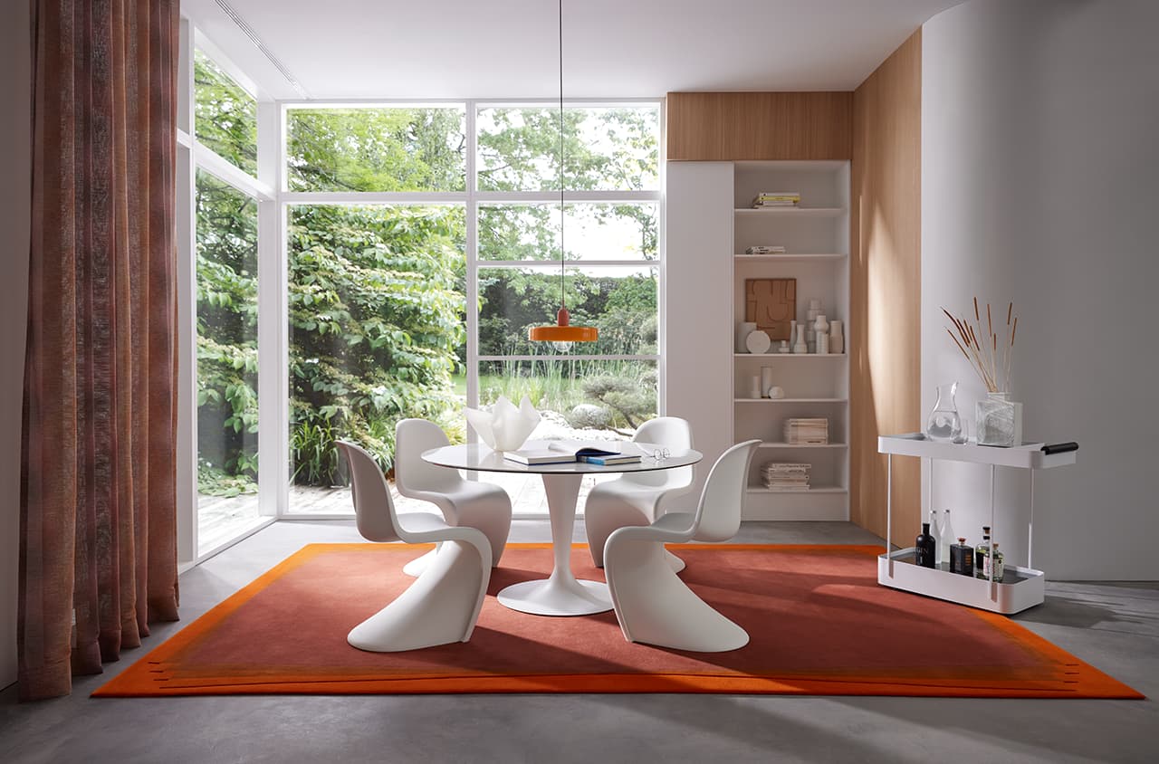 Teppich Contour Bliss in orange in einer Raumsituation mit einem Esstisch und Stühlen