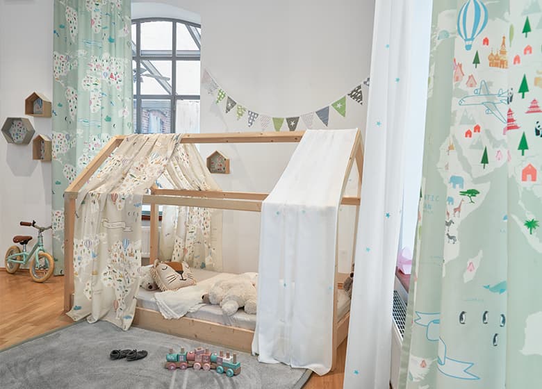 Kinderzimmer mit grüner Gardine und Bett