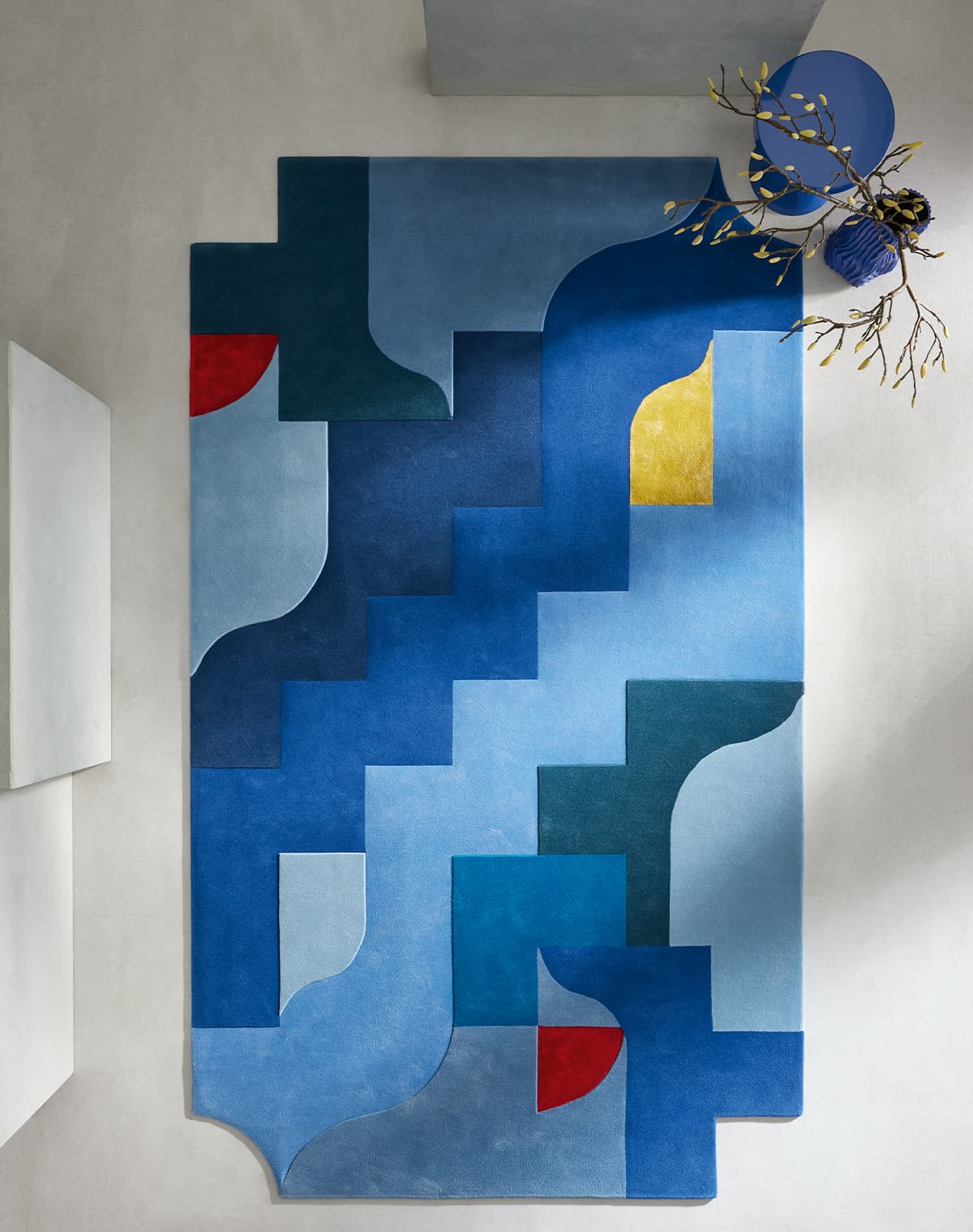 Teppichdesign in verschiedenen blauen Tönen mit etwas rot und gelb und verschiedenen geometrischen Formen