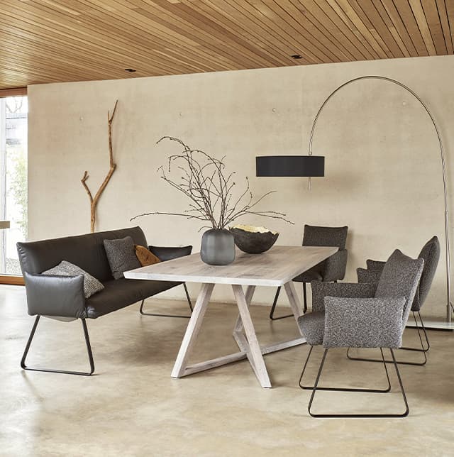 Graue Stühle und eine Schwarze Leder Dining-Bank um einen weißen Tisch