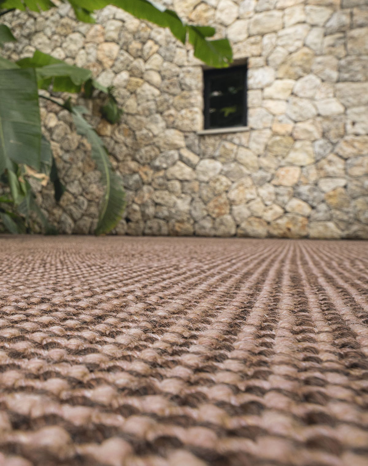 Outdoor-Teppich in braun vor einer Steinwand