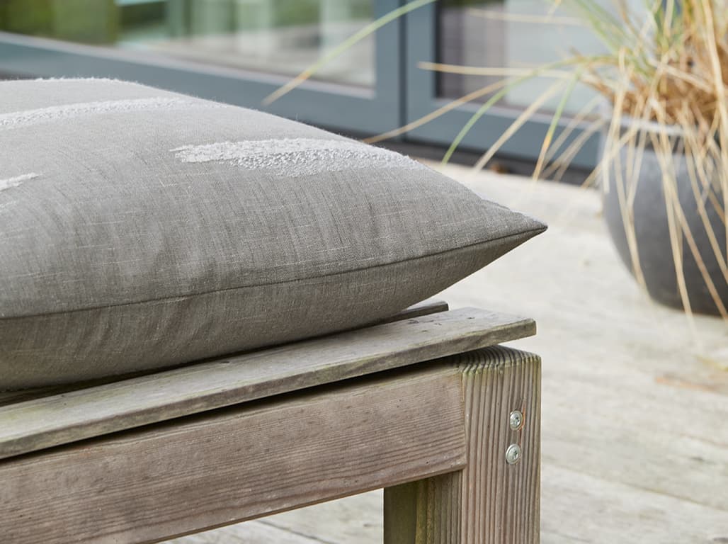 Graues Kissen auf einem Hocker