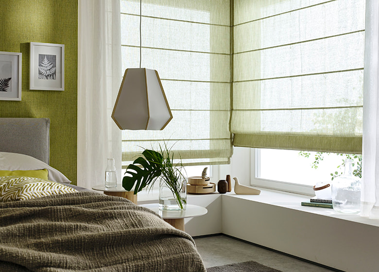 Schlafzimmer mt grünen Faltrollos am Fenster