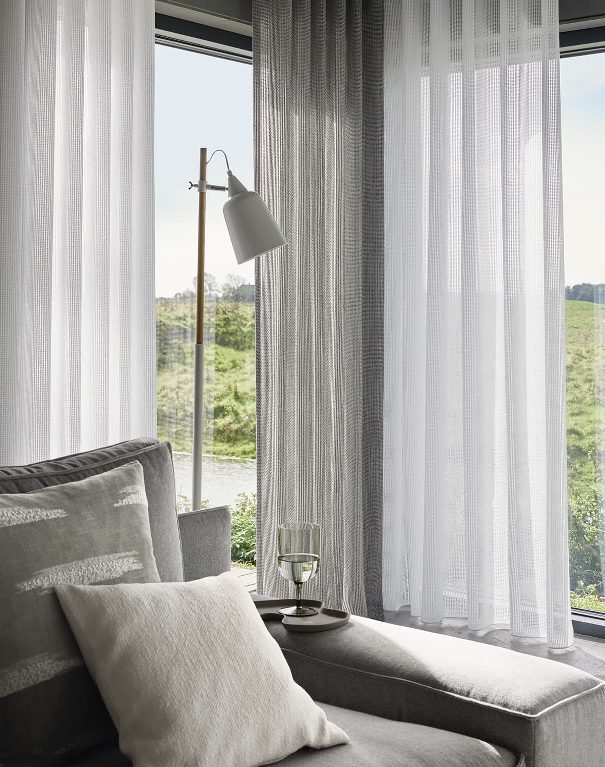 Graue und weiße Gardinen am Wohnzimmerfenster