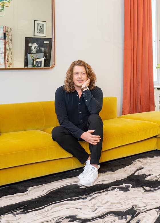Portrait von Frank Stüve auf einer gelben Couch 